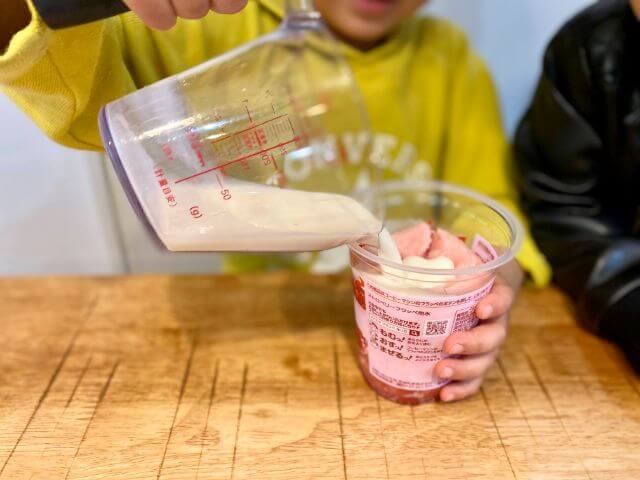 ファミマの2022ストロベリーフラッペにミルクを注ぎながら作っている写真